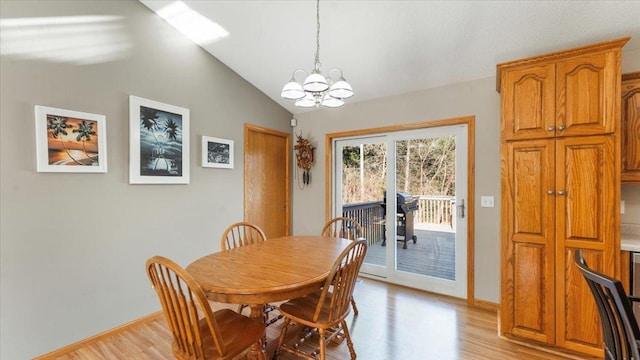 9112 Indigo Rd NW, Watab Twp, MN 56367 - dining area with a chandelier, vaulted ceiling, light wood-style flooring, and baseboards