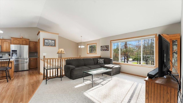 9112 Indigo Rd NW, Watab Twp, MN 56367 - living room featuring an inviting chandelier, vaulted ceiling, light wood finished floors, and baseboards