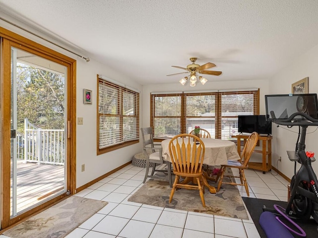 dining area with light tile patterned floors, baseboards, ceiling fan, and a textured ceiling