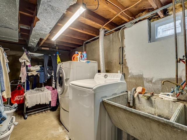clothes washing area with a sink, laundry area, and washer and dryer