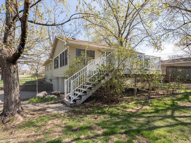 back of house featuring fence and a deck
