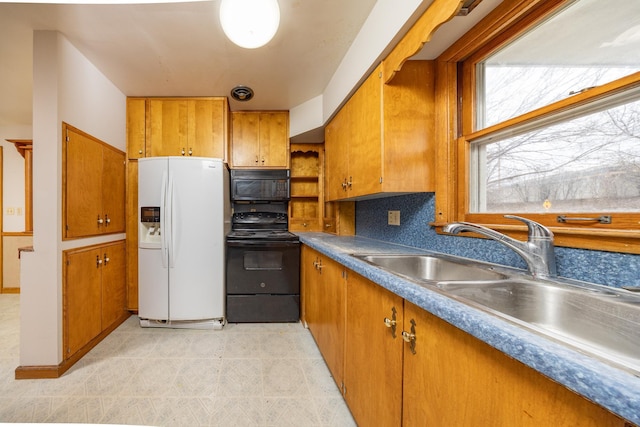 kitchen featuring open shelves, light tile patterned flooring, black appliances, brown cabinetry, and a sink