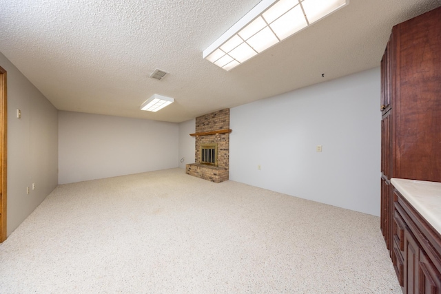 unfurnished living room featuring a fireplace, carpet, visible vents, and a textured ceiling