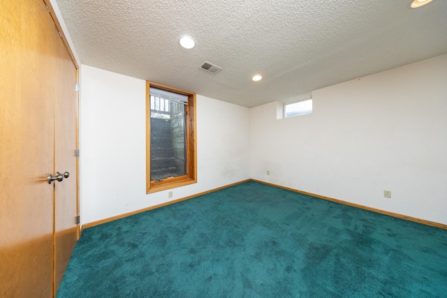 carpeted spare room featuring a textured ceiling, baseboards, visible vents, and recessed lighting