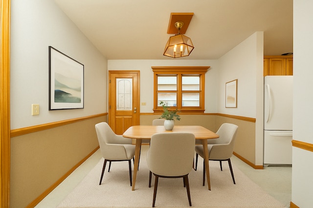 dining area featuring baseboards and light colored carpet