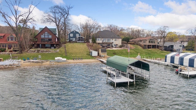 view of dock with a residential view, a lawn, a water view, and boat lift