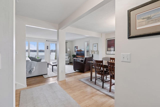 foyer featuring beamed ceiling, a water view, and wood finished floors