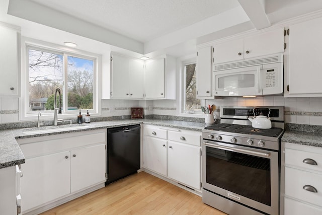 kitchen with tasteful backsplash, a sink, stainless steel gas stove, dishwasher, and white microwave