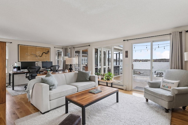 living area with a textured ceiling, wood finished floors, and baseboard heating