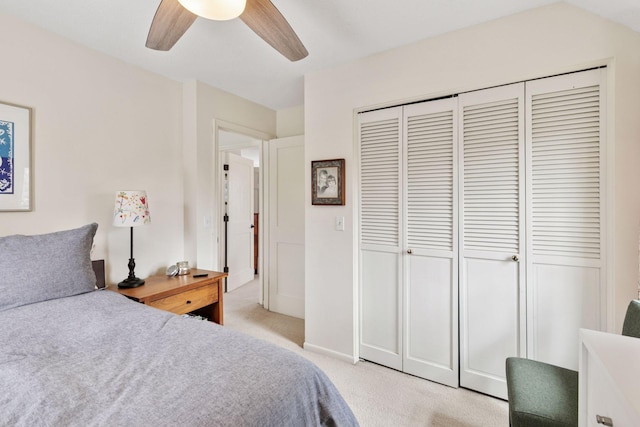 bedroom with ceiling fan, a closet, baseboards, and light carpet