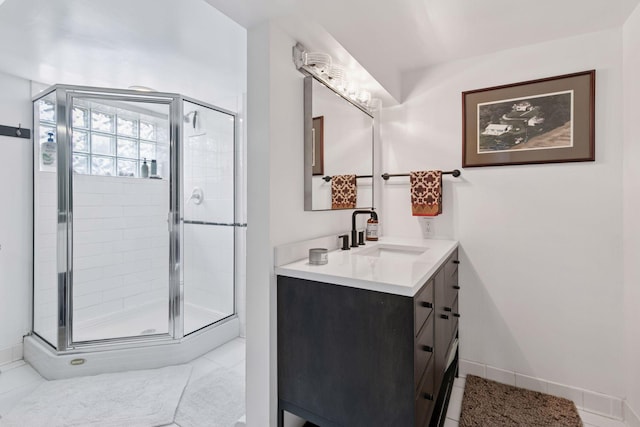 full bath featuring baseboards, a shower stall, tile patterned flooring, and vanity
