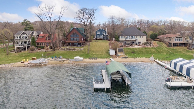 view of dock featuring a residential view, a water view, and a yard