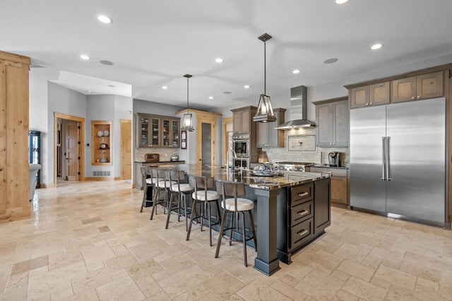 623 Shore Dr, Forest Lake, MN 55025 - kitchen featuring backsplash, a kitchen bar, stone tile flooring, stainless steel appliances, and wall chimney exhaust hood