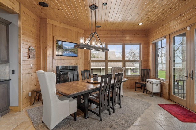 623 Shore Dr, Forest Lake, MN 55025 - dining area featuring a glass covered fireplace, wooden ceiling, wood walls, and stone tile flooring