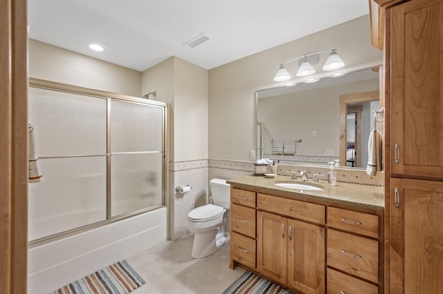 623 Shore Dr, Forest Lake, MN 55025 - full bath featuring tile walls, a wainscoted wall, bath / shower combo with glass door, vanity, and toilet