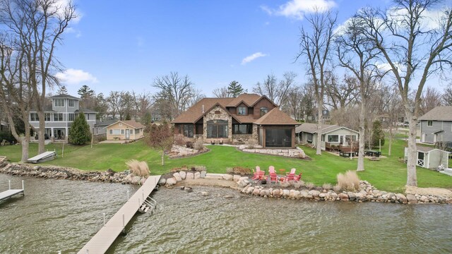 623 Shore Dr, Forest Lake, MN 55025 - back of property featuring a yard, a water view, stone siding, and an outdoor fire pit