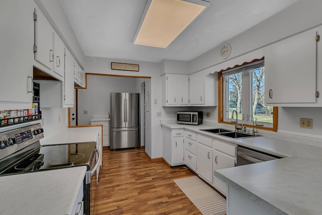 330 8th St E, Hector, MN 55342 - kitchen with stainless steel appliances, a sink, wood finished floors, and light countertops