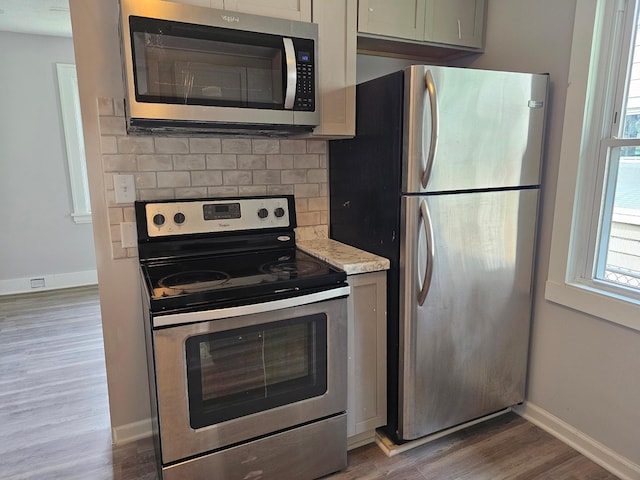 4517 4th Ave S, Minneapolis, MN 55419 - kitchen with stainless steel appliances, wood finished floors, backsplash, and light stone countertops