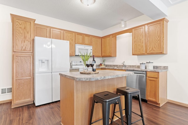 12172 Waconia St NE Unit C, Blaine, MN 55449 - kitchen with white appliances, dark wood-style flooring, a kitchen island, a breakfast bar, and light countertops
