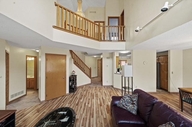 10695 53rd Ave N, Plymouth, MN 55442 - living area featuring stairs, light wood finished floors, a high ceiling, and baseboards