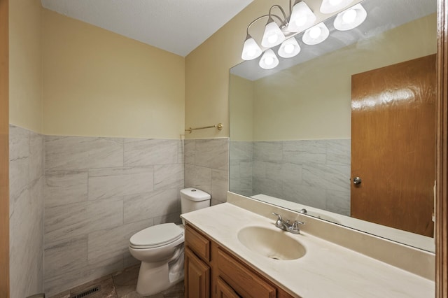 10695 53rd Ave N, Plymouth, MN 55442 - bathroom featuring tile walls, toilet, vanity, and a wainscoted wall