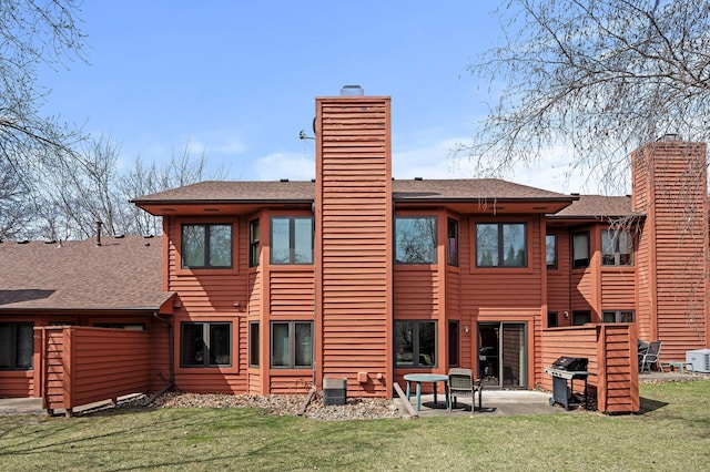 10695 53rd Ave N, Plymouth, MN 55442 - rear view of house featuring a chimney, a yard, a shingled roof, and a patio area