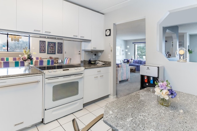 10411 Cedar Lake Rd Unit 301, Minnetonka, MN 55305 - kitchen with light tile patterned floors, white cabinetry, light stone countertops, and electric stove