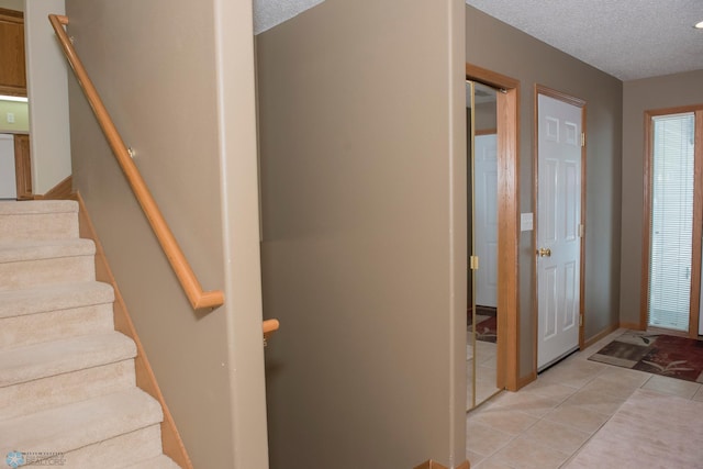 3220 40th Ave S Unit D, Fargo, ND 58104 - foyer entrance featuring stairs, light tile patterned floors, a textured ceiling, and baseboards