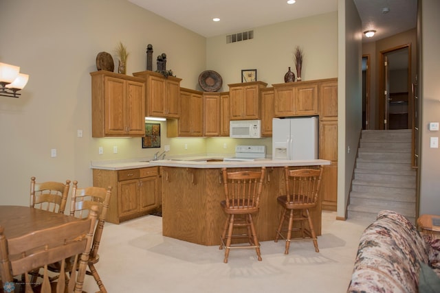 3220 40th Ave S Unit D, Fargo, ND 58104 - kitchen with white appliances, a kitchen breakfast bar, visible vents, a center island, and light countertops
