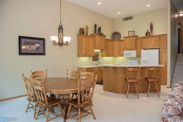 3220 40th Ave S Unit D, Fargo, ND 58104 - kitchen with white appliances, light colored carpet, visible vents, a sink, and light countertops