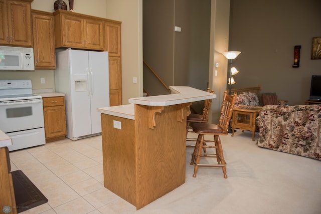 3220 40th Ave S Unit D, Fargo, ND 58104 - kitchen featuring a kitchen bar, brown cabinets, light countertops, and white appliances