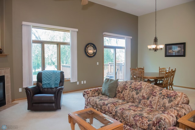 3220 40th Ave S Unit D, Fargo, ND 58104 - carpeted living area with a tiled fireplace, ceiling fan with notable chandelier, baseboards, and lofted ceiling