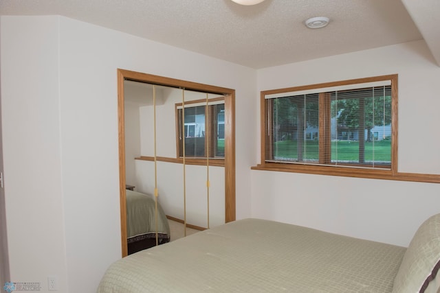 3220 40th Ave S Unit D, Fargo, ND 58104 - bedroom featuring a closet and a textured ceiling