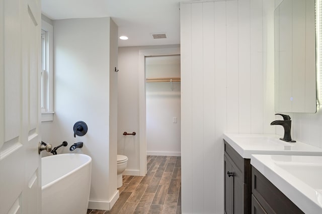 24182 184th St NW, Orrock Twp, MN 55309 - bathroom featuring vanity, a soaking tub, wood finished floors, toilet, and recessed lighting