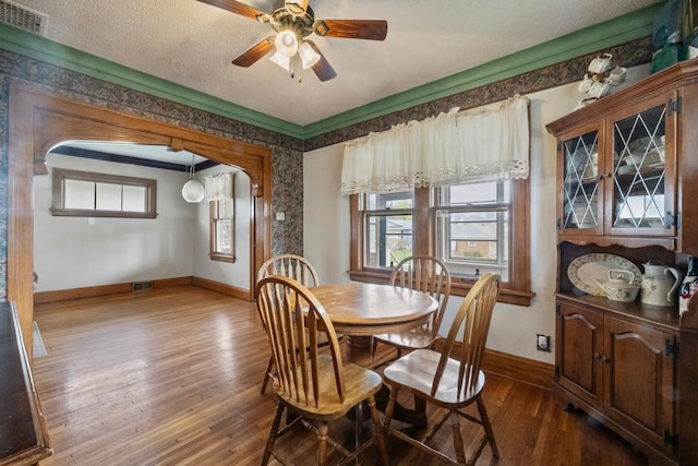 dining space with baseboards, dark wood-style flooring, visible vents, and a ceiling fan
