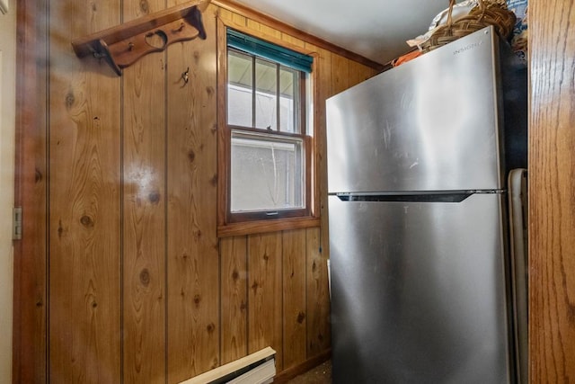 kitchen with freestanding refrigerator and wood walls