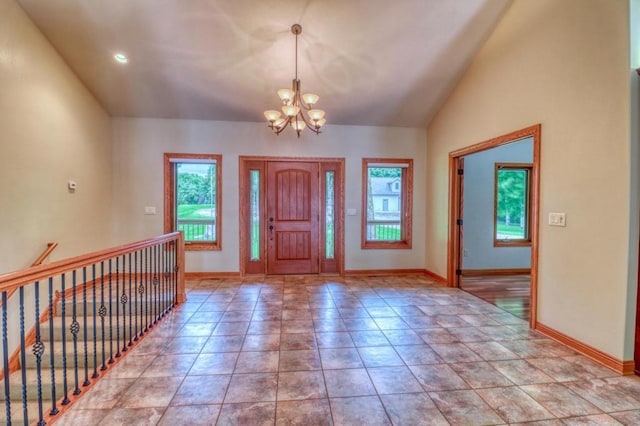 foyer featuring baseboards, vaulted ceiling, and a chandelier