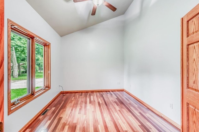 unfurnished room with ceiling fan, visible vents, light wood-style floors, baseboards, and vaulted ceiling