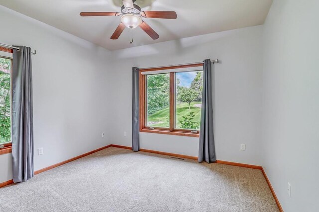 spare room with visible vents, carpet flooring, and a healthy amount of sunlight