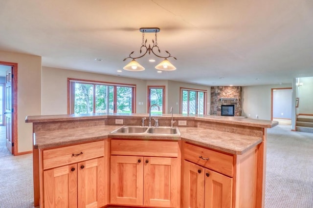 kitchen featuring a sink, light brown cabinetry, light carpet, and open floor plan