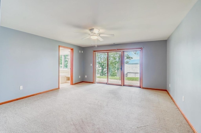 empty room featuring a ceiling fan, baseboards, and light carpet
