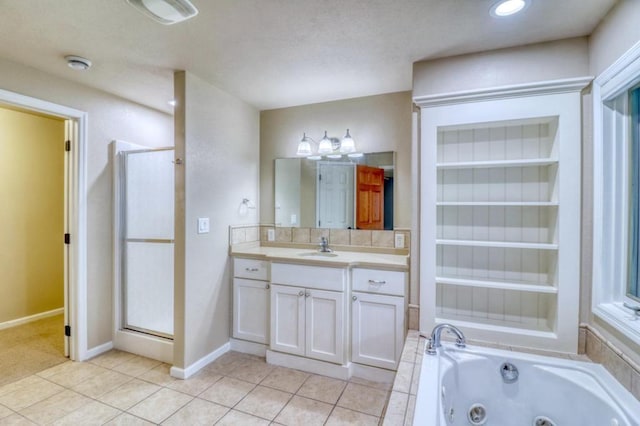 bathroom featuring tile patterned flooring, vanity, a tub with jets, baseboards, and a stall shower