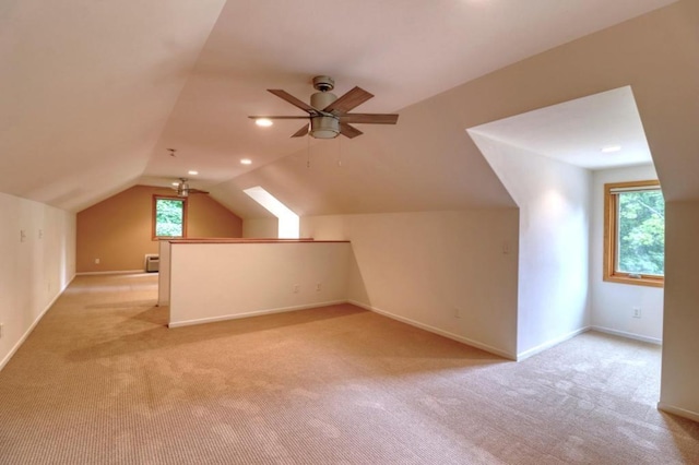 bonus room featuring light colored carpet, baseboards, ceiling fan, and vaulted ceiling