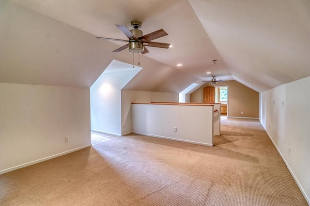 additional living space featuring a ceiling fan, baseboards, light colored carpet, and lofted ceiling