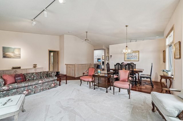 living room featuring lofted ceiling, carpet floors, and track lighting