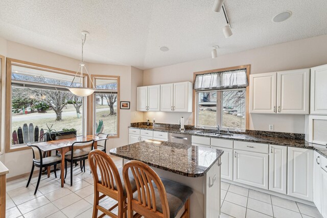 kitchen with light tile patterned floors, white cabinetry, and a sink