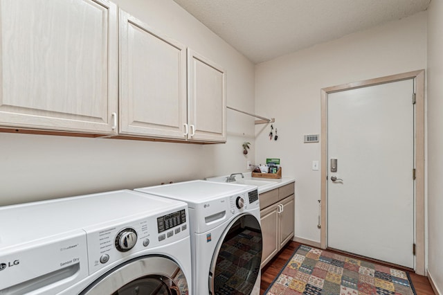 laundry room with a sink, cabinet space, washing machine and dryer, and wood finished floors