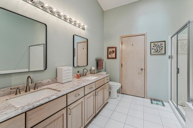 bathroom with toilet, a stall shower, double vanity, and a sink