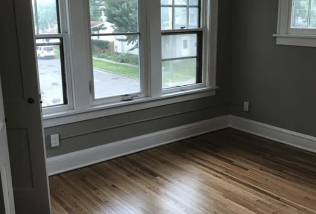 unfurnished room with dark wood finished floors and baseboards
