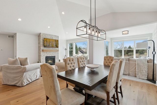 dining space featuring visible vents, recessed lighting, a notable chandelier, light wood-style floors, and a stone fireplace
